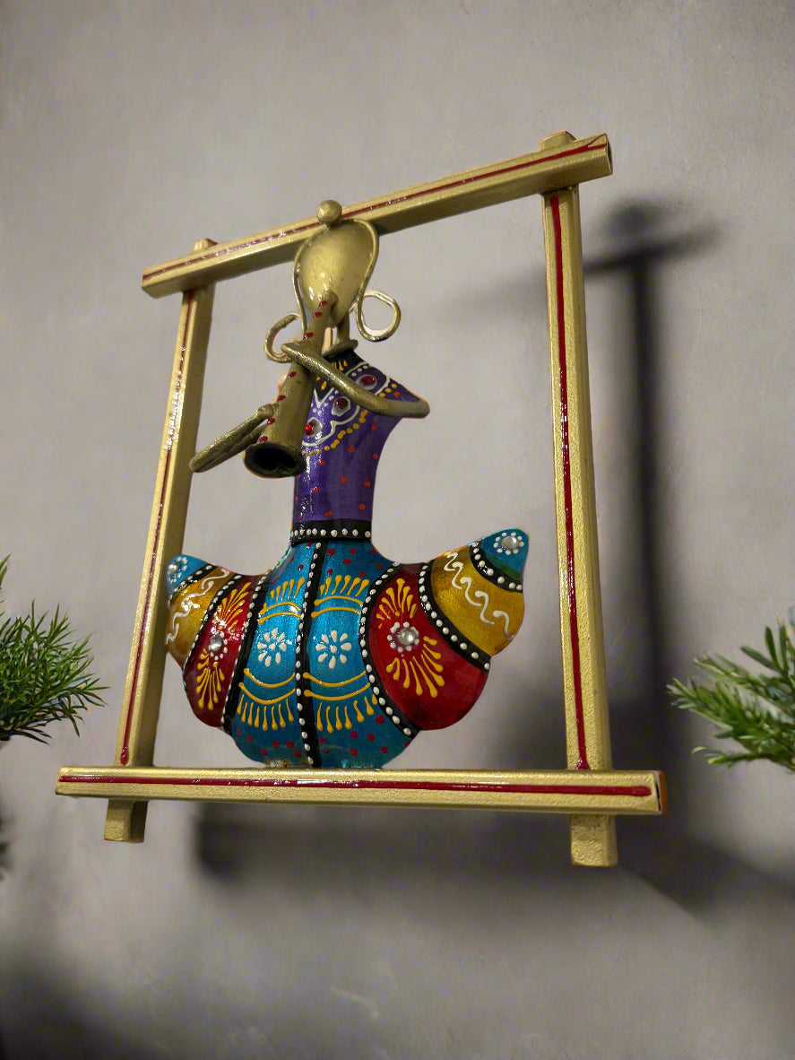 Decorative wall art with a colorful bird figure and gold frame on a white wall.